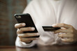 © EduLife Photos - Close up of a teenage woman holding credit card and smart phone make online payment. Stock photo.