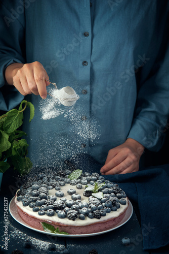Cuadros en Lienzo Female hands sprinkle with icing sugar cottage cheese casserole