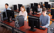 adult concentrated people of different ages learning to use computers in classroom
