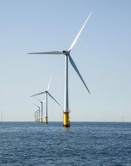 Wind turbines in an offshore wind farm in the North Sea just off the coast of the Netherlands, on a clear day.