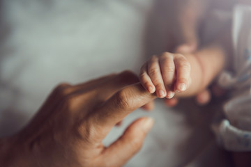 newborn baby holding mother's hand.