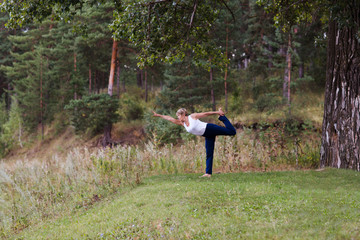 Wall Mural - senior woman doing stretching exercise outdoors on a summer morning.  yoga. Social Distancing. copy space. Mental Health.