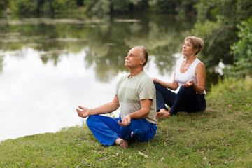 Wall Mural - Senior family couple practising meditation outdoors.  yoga. Social Distancing. copy space. Mental Health.