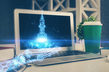 Desktop computer background in office and start up theme hologram drawing. Double exposure. Startup concept.