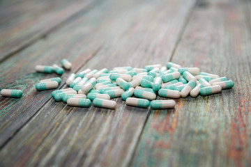 Wall Mural - Blue and white capsules on a wooden background