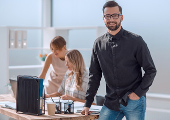 Wall Mural - smiling young business man standing in office