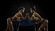 two young fitness woman, arm wrestling in gym