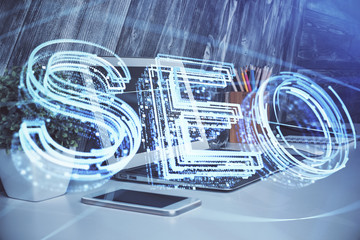 Multi exposure of table with computer and seo drawing hologram. Search optimization concept.