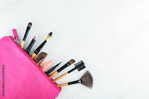 Fotografía set of makeup brushes in a pink cosmetic bag top view on white background