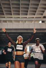 Wall Mural - Winning athlete crosses the finish line