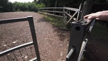 Opening A Steel Gate And Walking Through Into The Countryside