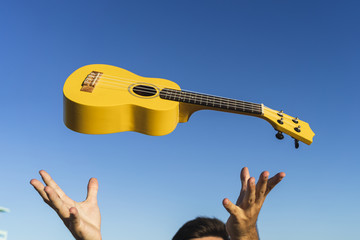 Sticker - Male throwing the ukulele up in the air while standing at the beach of San Fernando, Andalucia