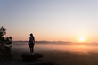 © Cavan Images - Silhouette of Girl hiking on mountain top at sunrise