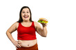 Hungry fat girl with excess weight holds a burger in her hand and looks at it, isolated on white