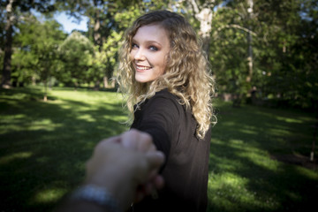 Sticker - Beautiful young model with blonde curly hair smiling to the photographer and holding his hand