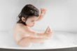 © Lisa Tichané - Cute toddler girl washing her foot in bathtub