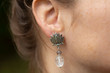 © marbenzu - Closeup of lotus shape crystal quartz earring on female ear