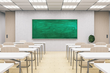 Light classroom interior with empty green chalkboard