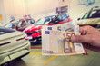 © RomanR - man buy new car giving euro banknotes