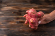 Womans hand holds trendy ugly organic potato from home garden on on a wooden background, unnormal vegetable or food waste concept, copy space