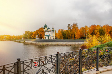 Wall Mural - Ancient christian church and autumn yellow trees. Beautiful domes, high old bell tower against the sky