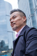 © View Stock - Middle-aged and old business man standing among buildings
