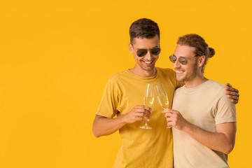 Sticker - Happy gay couple with champagne on color background