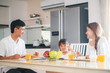 © tuastockphoto - Happy Asian family having delicious breakfast together in the kitchen at home. a domestic life and quality time together