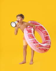 Poster - Cute little boy with inflatable ring and megaphone on color background