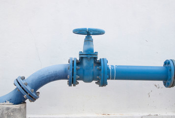 Large water supply valve with a white background of the cement wall