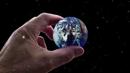 Wall Mural - video of universe or aerial flyby. camera moves towards hand holding planet earth while stars flyby.