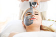 © Monster Ztudio - Woman relaxing with charcoal facial mask in spa room