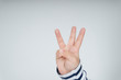 © THESHOTS.CO - Kid hand with three fingers gesture.