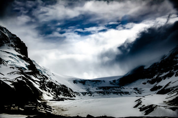 Poster - Beautiful scenery of a mountainous landscape with rocky mountains covered with snow under sunlight