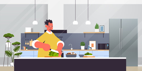 Wall Mural - happy man cutting lettuce preparing fresh vegetables salad healthy nutrition cooking at home concept modern kitchen interior horizontal portrait vector illustration