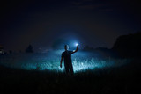 Fototapeta Psy - Person with flashlight at night