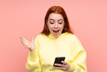 Redhead Teenager Girl Over Isolated Pink Background Surprised And Sending A Message