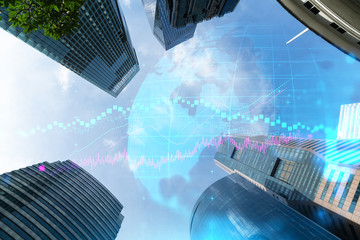 FOREX and stock market chart hologram on low, wide angle view of glass and steel contemporary skyscrapers in financial downtown. The concept of international trading. Double exposure.