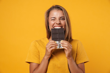 Wall Mural - Image of blonde joyful woman winking and holding chocolate