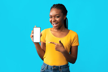 African Girl Showing Mobile Phone Empty Screen Over Blue Background