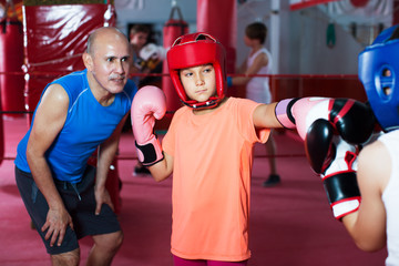 Wall Mural - Group of kids practicing with mentor on boxing ring at gym