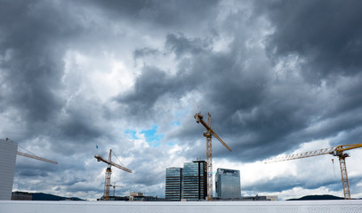 construction site with cranes and clouds.