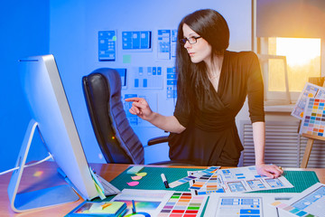 Wall Mural - a girl selects a color solution for the program of ordering products. mobile app designer. applicati