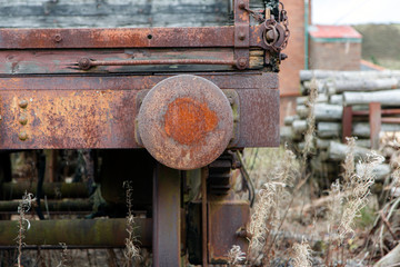 Big Pit was a working coal mine from 1880 to 1980. It is now obsolete and closed. Exterior of an old building with broken and discarded machinery scattered on the ground.

