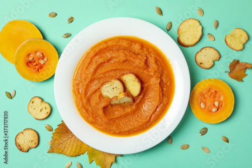 Fotomural Composition with plate of pumpkin soup on mint background