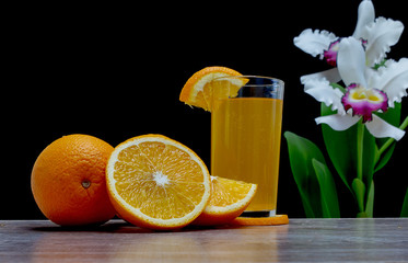 Orange juice in a glass and an orange fruit on the ground