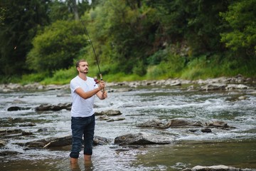 Bearded man catching fish. Summer leisure. Mature man fishing on the pond. Portrait of cheerful senior man fishing. Male fishing. Fishman crocheted spin into the river waiting big fish