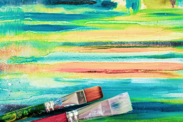 Bright painted canvas of artist and dirty artistic brushes, texture of mixed artistic oil paints, different colors, mix spots, blots, modern creative background