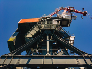 Large gantry crane against a blue sky on a sunny summer day.