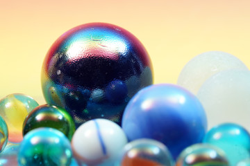 Sticker - Closeup shot of colorful glass balls  on a colorful background